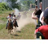 robbers shooting from horses by the train